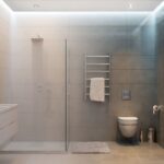 A modern bathroom featuring a contemporary shower enclosure, glass frame shower, and sleek sink.
