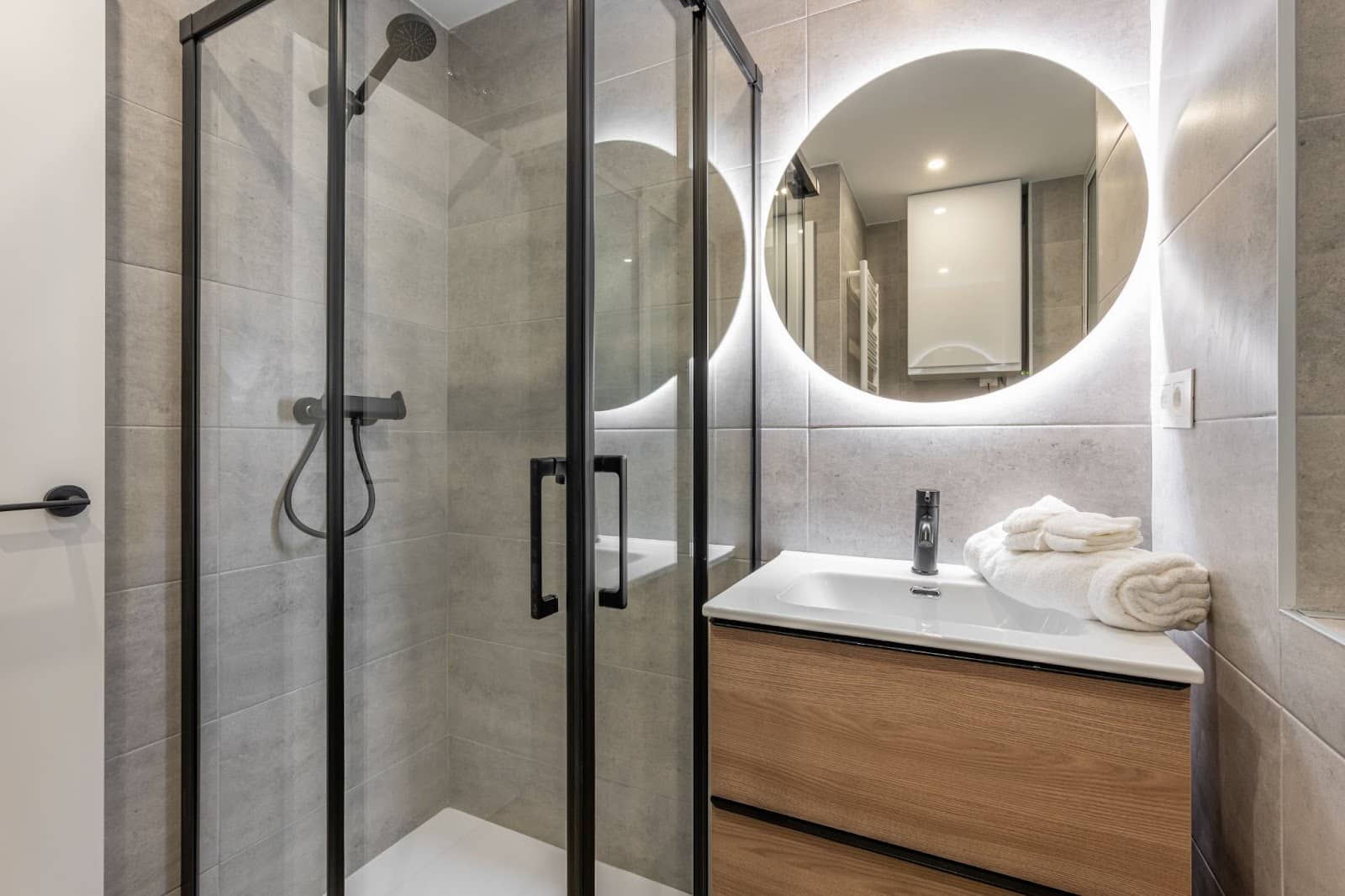 A contemporary bathroom interior with a glass-enclosed shower and a stylish sink, highlighting modern design aesthetics.