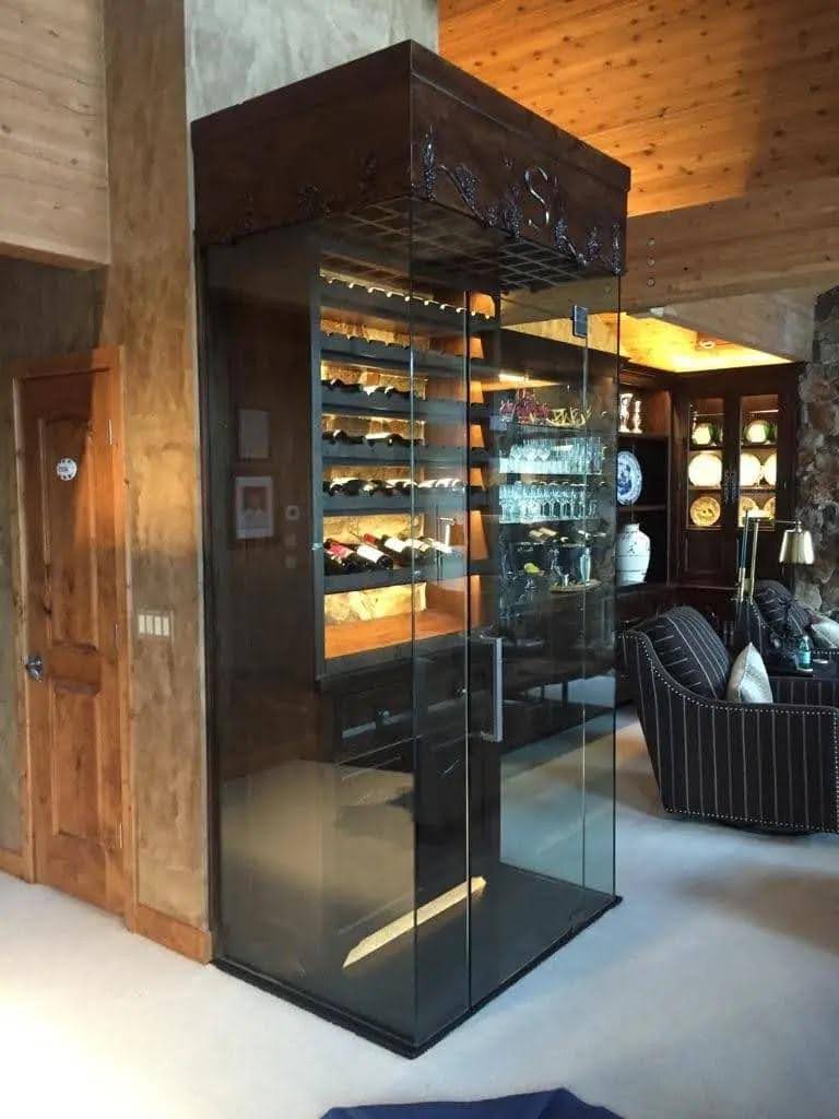 Interior of a wine cellar with a glass door and chairs for guests to relax